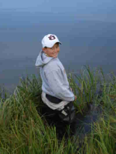 Dakota trying out the waders at the edge of the pond