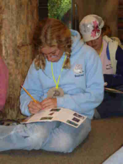 Erin listens to bird songs, making notes in her bird book