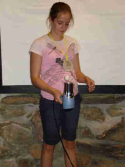 Janie demonstrating Bernoulli's Principle - the ping pong ball doesn't get blown out of the air stream because the slower moving air on top of the ball pushes harder than the fast moving air underneath the ball.